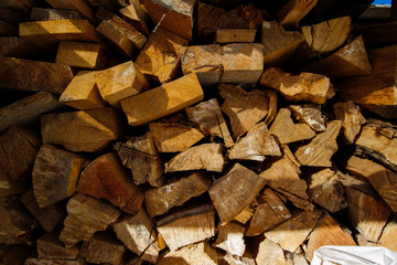 Wooden firewood stacked in a pile in firewood. Firewood in firewood