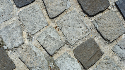 Cobble stones in concrete on a path, background texture macro, selective focus