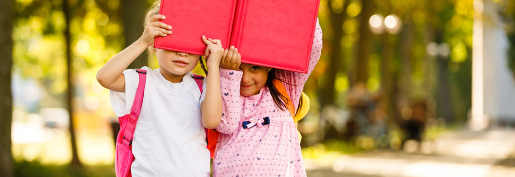 School time of girls. Friendship of small sisters Happy school kids at lesson in september 1. Back to school and home schooling.