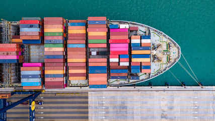 Obraz premium Cargo ship loading and unloading goods at the deep sea port