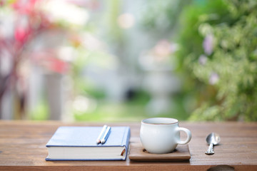 White cup with diary notebook at outdoor