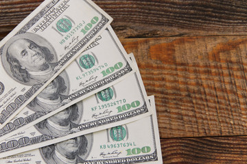 One hundred american dollars banknotes on wooden table. Top view, copy space