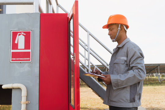 safety officer working on checking Fire extinguisher at outdoor plant