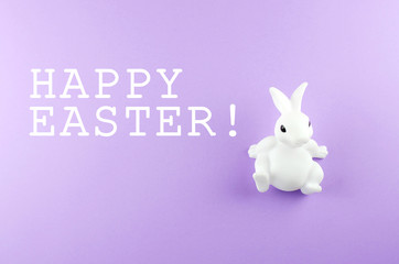 Toy Easter white bunny on a light purple background.
