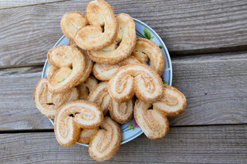 Palmier cookies in a plate on wooden table