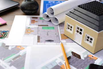 Drawings, layout of the house, documents, calculator on the desktop in the office. Engineering, construction, business.