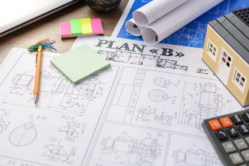 Drawings, layout of the house, documents, calculator on the desktop in the office. Engineering, construction, business.