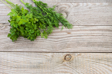 Fresh parsley and dill on rustic wooden table