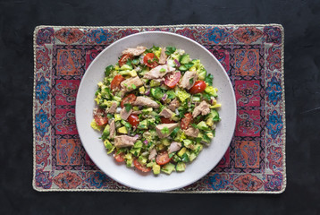 Avocado Tuna Salad in a plate on black table. 