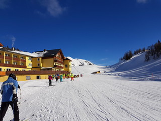 Skifahrer vor einer Hütte auf einer Skipiste