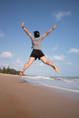 young woman jumping on the beach