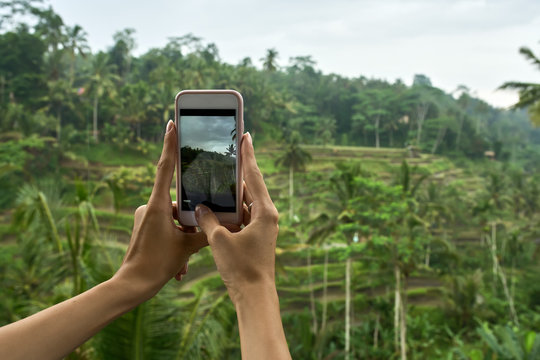 Woman shooting photo on terraced rice fields background on Bali