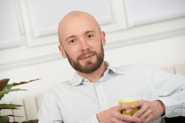 young man with a beard drinking cup of coffee