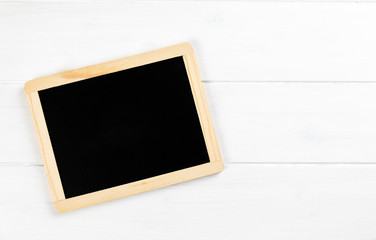 chalkboard on white wooden background with copy space