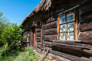 Old wooden house made of logs with a roof made of straw - Polissya, Ukraine