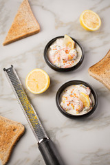Garnelen Salat mit Lachs Kaviar,  Kräuter, Zitrone, und Vollkorn Toast Brot in schwarzer Schale auf Marmor Hintergrund