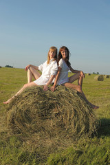 Naklejka na ściany i meble two women in white shirts in a field