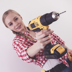 Woman using drill on wall