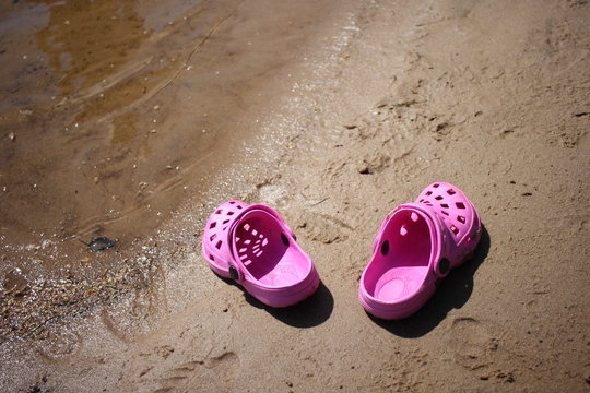 Pink childrens sandals on the beach