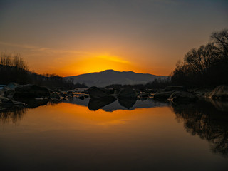Fototapeta premium Beautiful landscape stones in mountain lake, reflection, blue sky and yellow sunlight in sunrise. Ukraine. Amazing scene