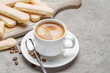 Italian Savoiardi ladyfingers Biscuits and cup of coffee on concrete backgound