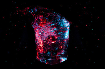 Big colorful splash from a rocks glass isolated on a black background