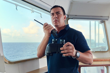 Portrait of navigator pilot officer on the bridge of the vessel