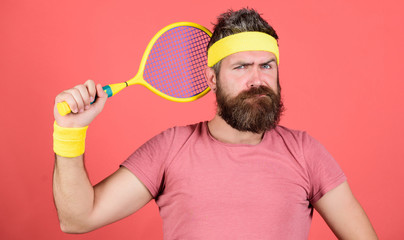 Athlete hold tennis racket in hand on red background. Tennis sport. Tennis club concept. Man bearded hipster wear old school sport outfit with bandages. Tennis can be an effective way to lose weight