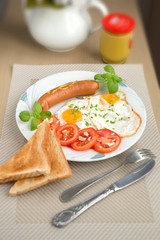 food breakfast fried eggs with sausage tomatoes basil and garlic on the table