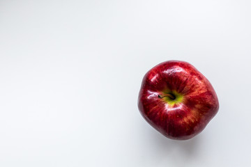 Red juicy apple on white photne, close-up, top view