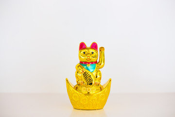 Maneki Neko plastic Japanese lucky cat figures on white backgrund.Japanese characters means good...