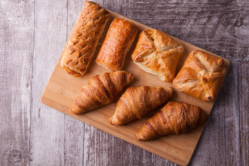 An assortment of freshly baked pastry aligned on cutting board