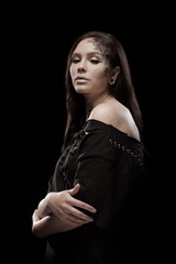 portrait of young brunette girl with black tears from eyes and lace pattern on face and neck posing...