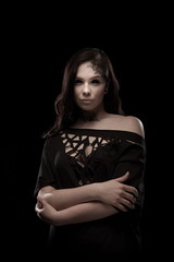 portrait of young brunette girl with black tears from eyes and lace pattern on face and neck posing...