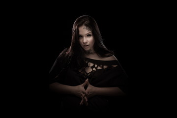 portrait of young brunette girl with black tears from eyes and lace pattern on face and neck posing...