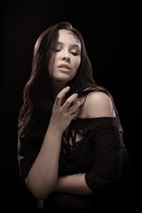 portrait of young brunette girl with black tears from eyes and lace pattern on face and neck posing...