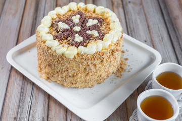Cake delicious on plate. Bakery, cream dessert cake with tea spot on wooden table