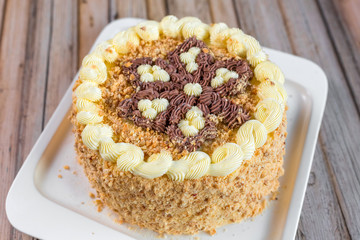 Cake delicious on plate. Bakery, cream dessert cake with tea spot on wooden table