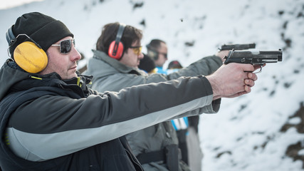 Group of civilian practice gun shooting on outdoor shooting range