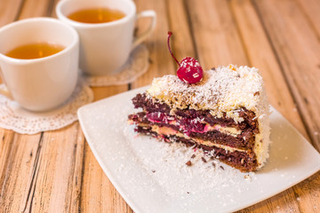 Cake delicious on plate. Bakery, cream dessert cake with tea spot on wooden table