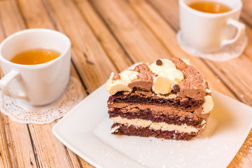 Cake delicious on plate. Bakery, cream dessert cake with tea spot on wooden table