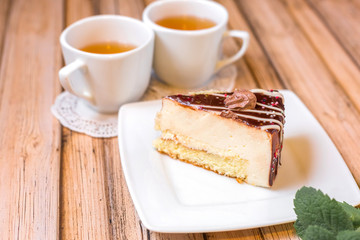 Cake delicious on plate. Bakery, cream dessert cake with tea spot on wooden table