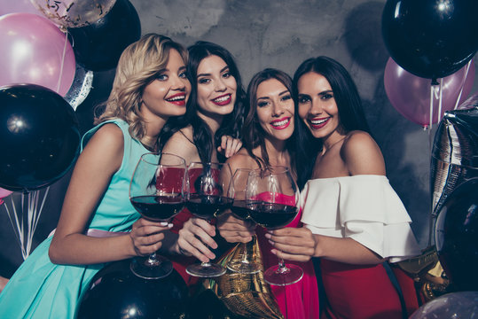 Portrait of four nice lovely exquisite fascinating chic attractive glamorous shine gorgeous cheerful cheery ladies clinking red wine evening occasion over gray concrete wall