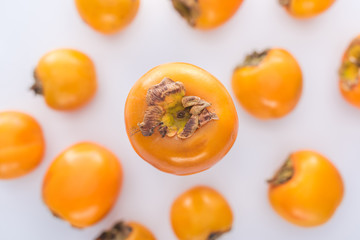 selective focus of sweet and whole persimmons on white background