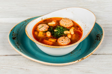 Bean soup on wooden white background close-up