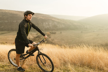 Fototapeta premium Young man on bicycle in countryside