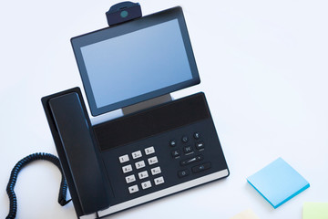 Ip telephony concept. Modern ip phones, sip terminals, conference phones and cameras for video meetings on office background. Top view.