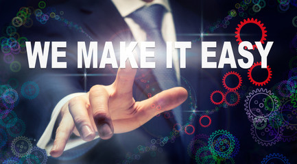 A businessman pressing a We Make It Easy business concept on a graphical display of cogs