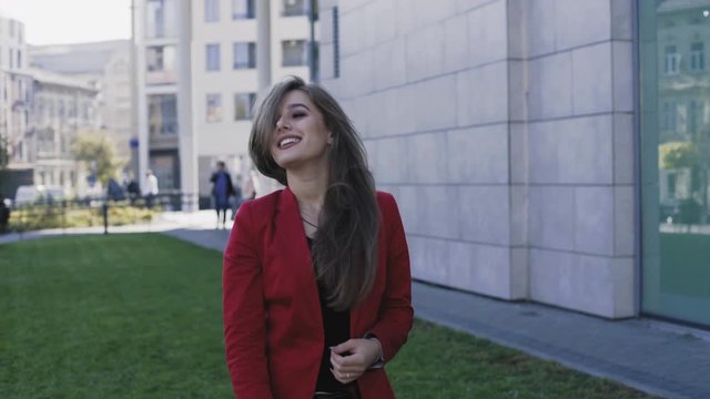 Beautiful lady in red suit walks, smiles and poses with her hair