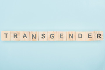 top view of transgender lettering made of wooden cubes on blue background
